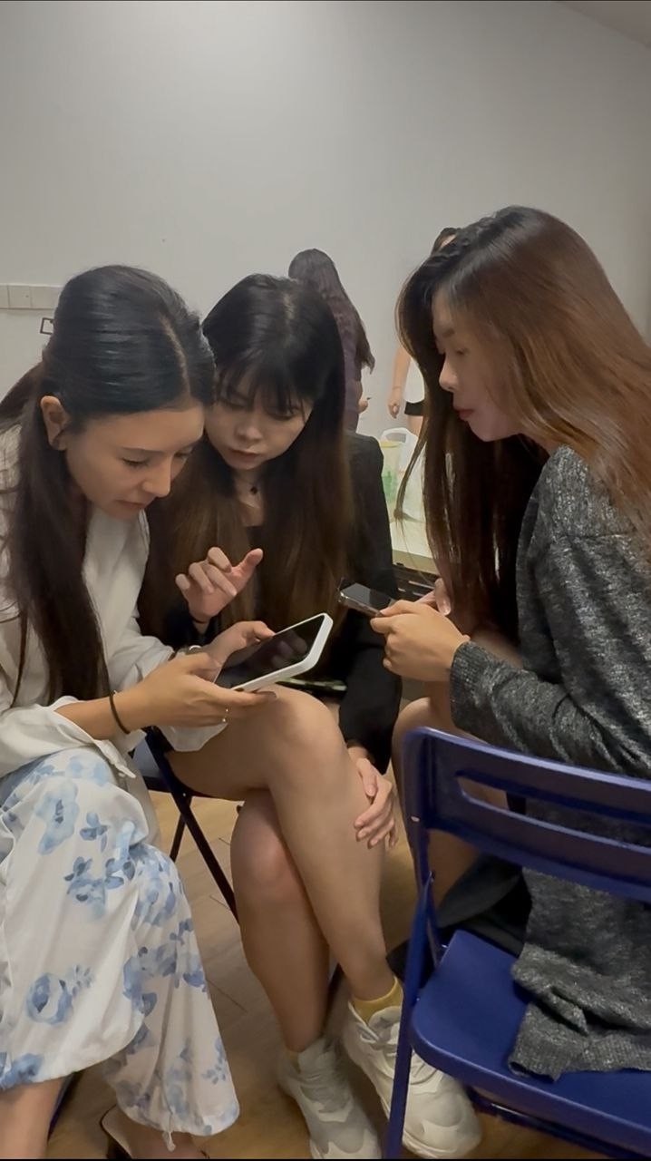 线下小组讨论：学员围坐桌前交流学习进度，助教在旁辅导